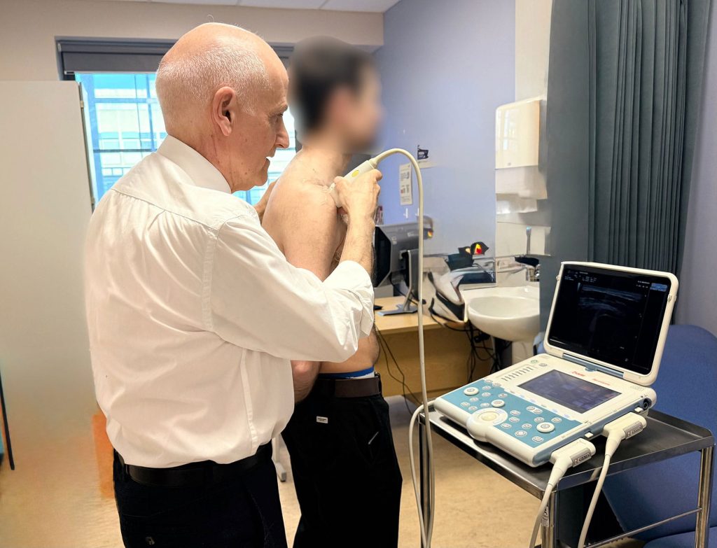 Mr Michael Kurer performing an ultrasound shoulder assessment 